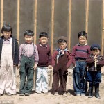 A group of children line up for a photo in front of a barrack wall. Billy Manbo is on the far right. Photo by Bill Manbo