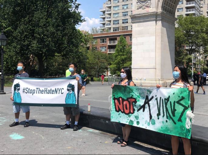 Banners read Not a virus and Stop the hate NYC
