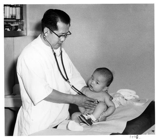 Dr. Julius Sue examining a baby in Los Angeles in 1948.