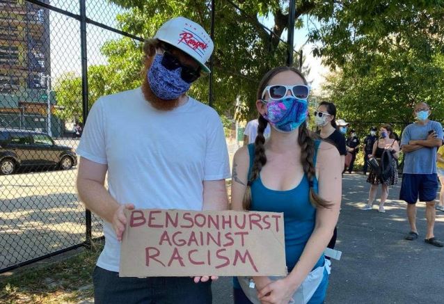 Couple holds up Bensonhurst against Racism sign at Asian Unity Rally