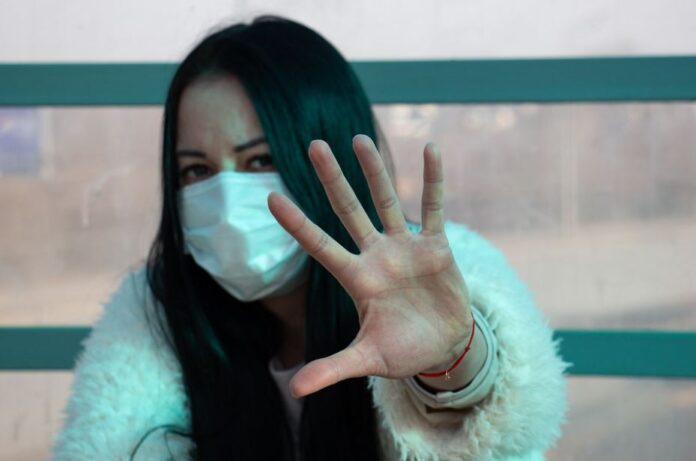 coronavirus woman in mask via Flickr by Nik Anderson