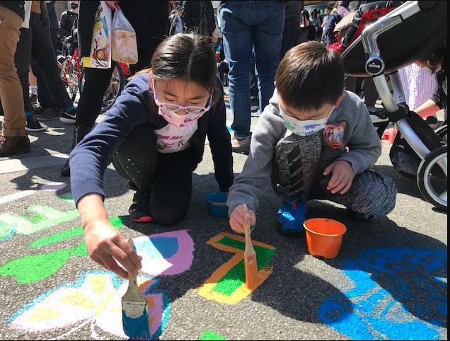 Children paint message using water-based paint on the concrete in Portsmouth Square in San Francisco Chinatown.