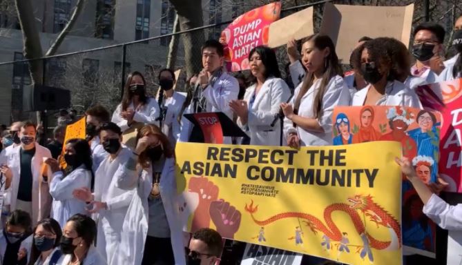 White coats take to the stage at a NY rally to stop Asian hate