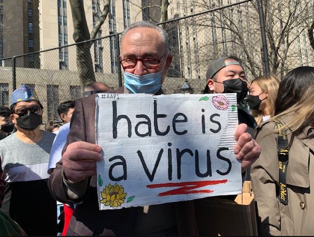 Senate Majority Leader Chuch Schumer holds up a 