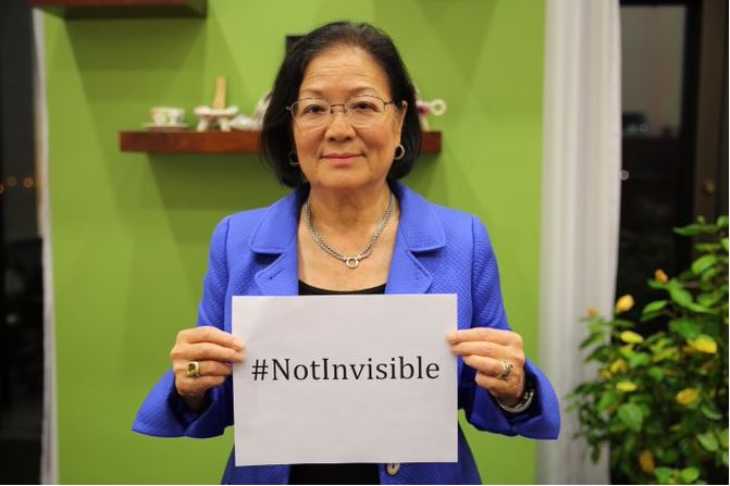 Senator Mazie Hirono holds up #NotInvisible sign