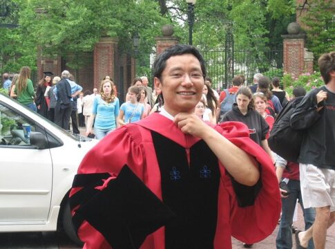 A Harvard student smiles broadly on graduation day