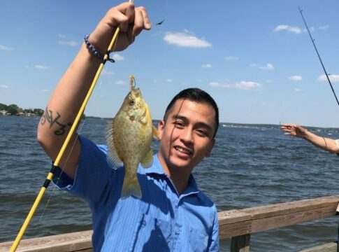 Angelo Quinto holds up a fish he caught
