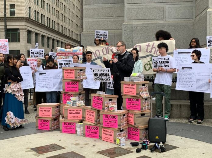 Protestors stand in front of boxes containing 15000 signatures and 3,000 postcards against the proposed Philadelphia 76er arena