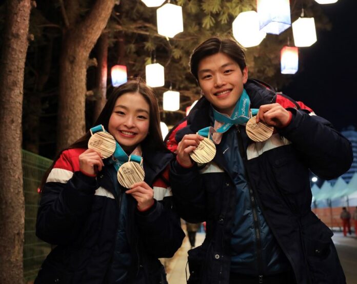 Alex and Maia Shibutani hold their two bronze Olympic medals