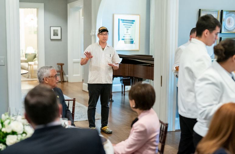 Chef Kevin Tien greets guests from the Congressional Asian Pacific American Caucus at the residence of Kamala Harris. Rep Judy Chu looks on