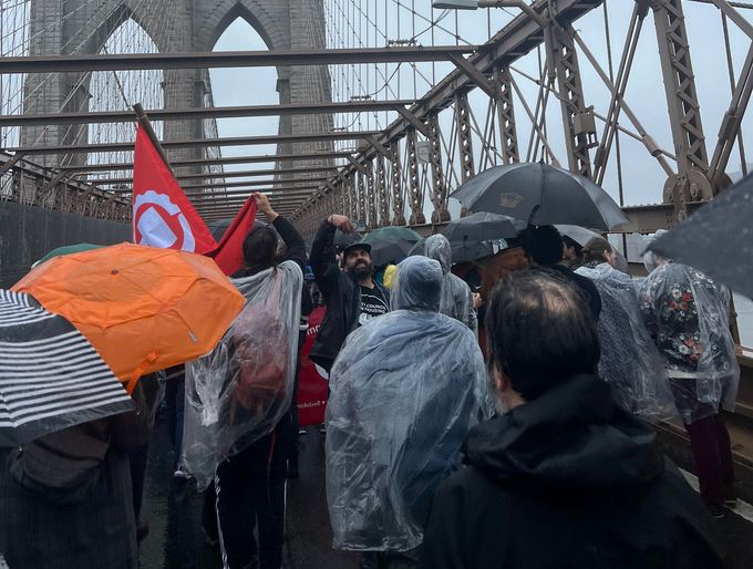 Protestors march in the rain across the Brooklyn Bridge calling for justice in housing.  