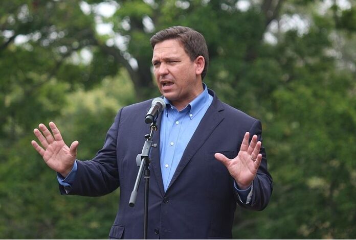 Ron Desantis puts his hands up while talking