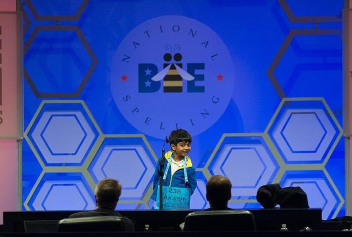 A young contestant smiles widely as he competes in the Scripps Spelling Bee.