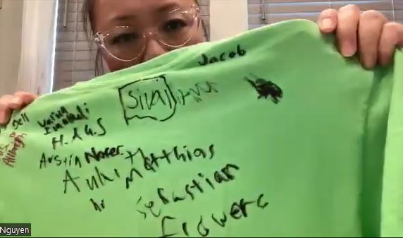 Au Huynh holds up her son's t-shirt showing where he scribbled over a swastika drawn on his back by another student