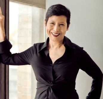Ellen Yin poses with one hand on her hip and the other leaning against the wall
