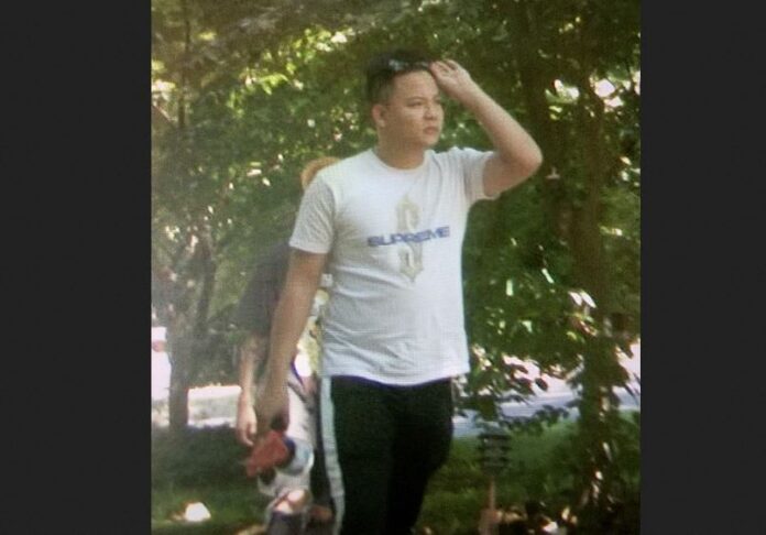 Zheng Congying is pictured in a t-shirt with glasses up on his head above the eyes