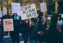 protestors hold up Stop Asian hate signs