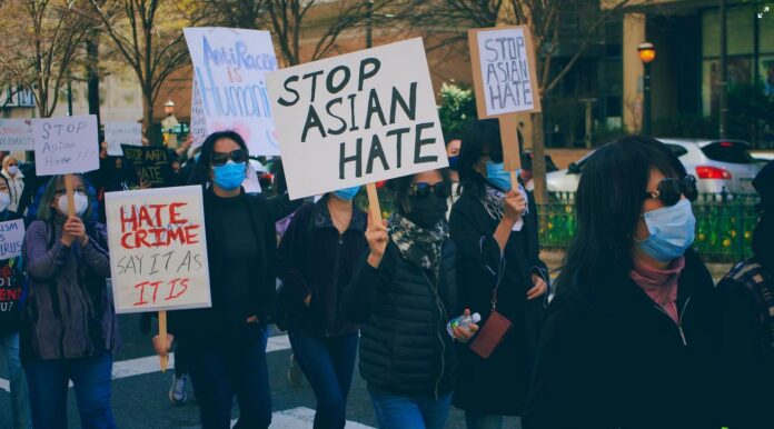 protestors hold up Stop Asian hate signs