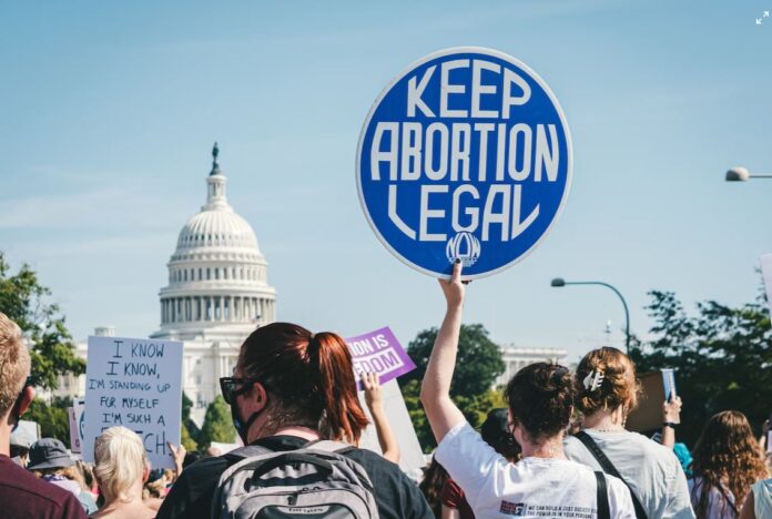 Keep abortion legal sign held up by protestor with U.S. Capitol building in the background