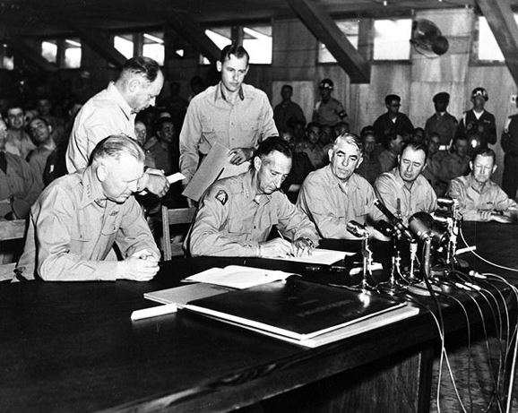 General Mark W. Clark, Far East commander, signs the Korean armistice agreement on July 27, 1953, after two years of negotiation.(U.S. Navy Museum photo)