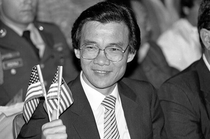 Academy Award winning actor Haing Ngor is seen here waving an American flag at his citizenship ceremony