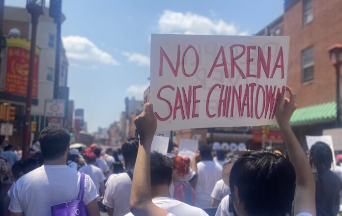 Protester holds up sign that reads No arena, save Chinatown