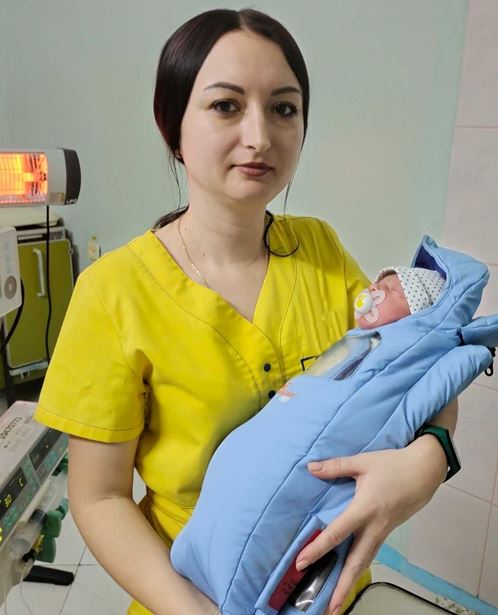 Nurse holds infant in Ukraine