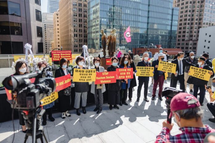 Anti-Asian hate protest as demonstrators hold signs in multiple langages