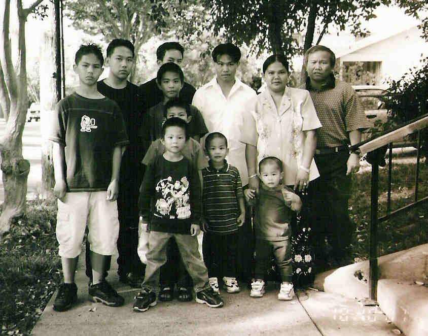 Phanat Xiong. left, with his family in the early 2000s, at the foot of the 19 steps up to the scary two-story house where his adolescent paranormal experiences began. Courtesy of Phanat Xiong Hmong ghost stories Hmong scary storytelling Halloween 2023 piece by Jia H. Jung
