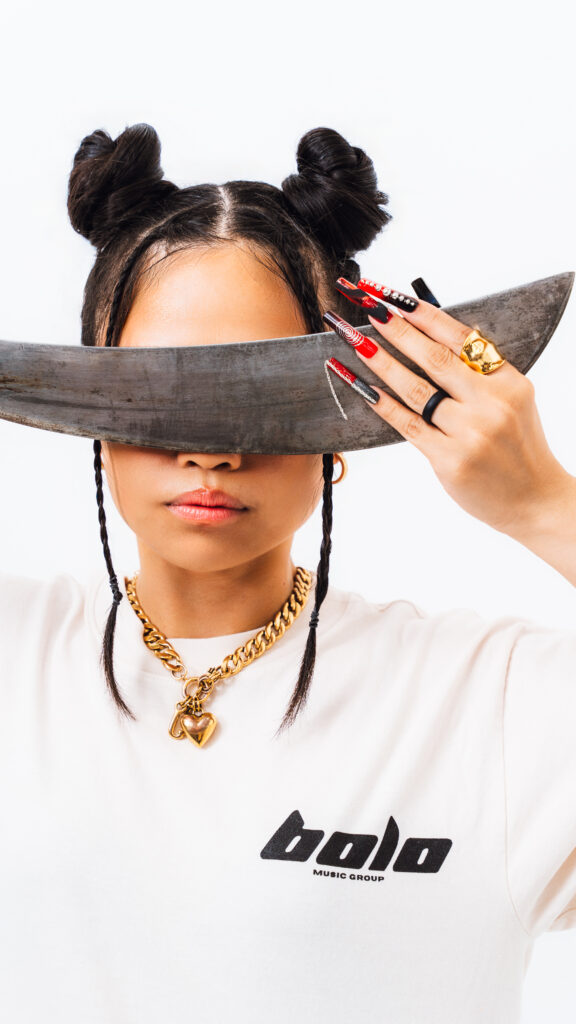 A promotional photo of Ruby Ibarra sporting a Bolo Music Group tee and holding a Filipino bolo over her eyes. Courtesy of Bolo Music Group.