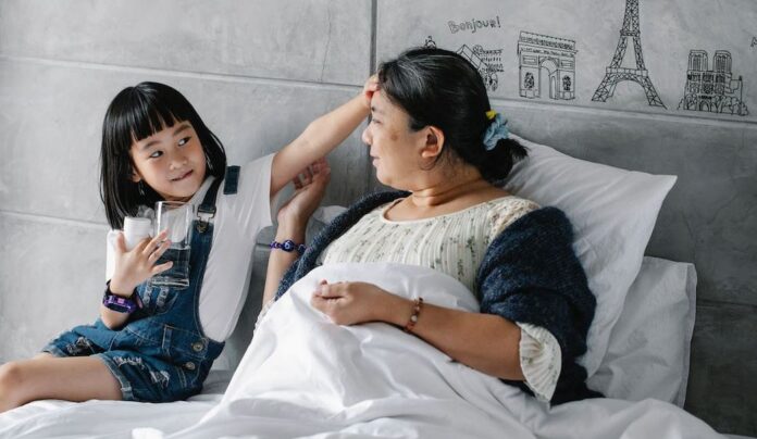 A young child is at the bedside of a woman patient