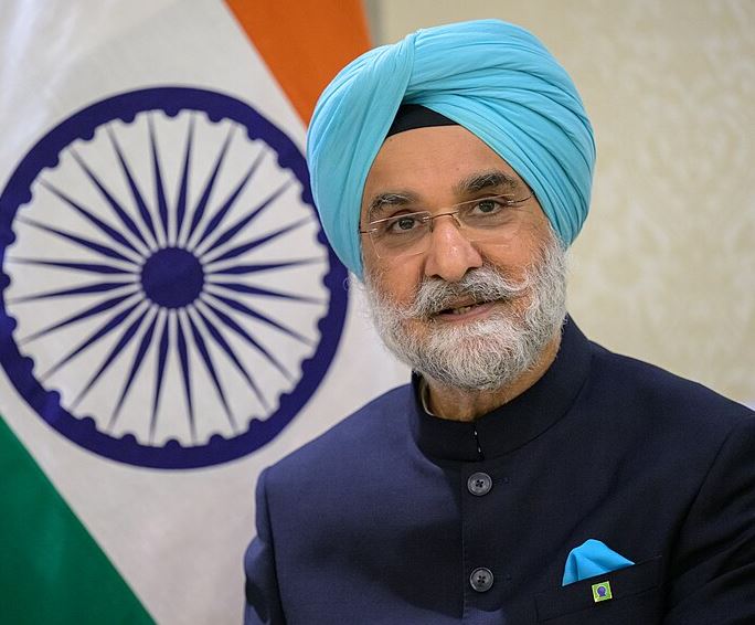 Taranjit Sandhu poses in front of the flag of India