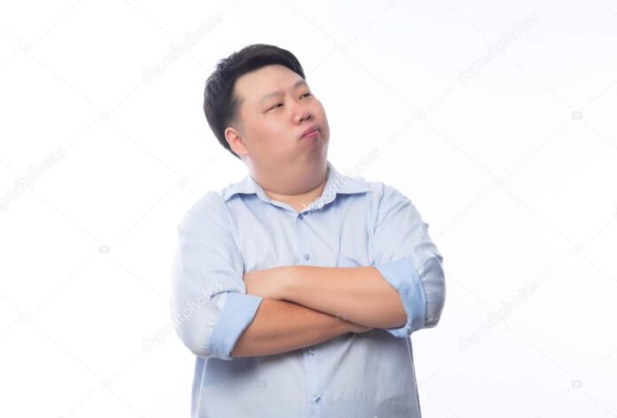 Asian American man with his arms folded while he looks disgusted