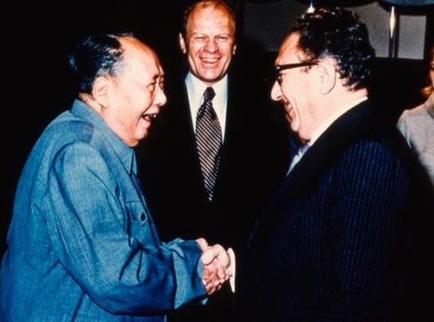 Henry Kissinger is seen smiling and shaking hands with Chinese Chairman Mao Tse Tung
