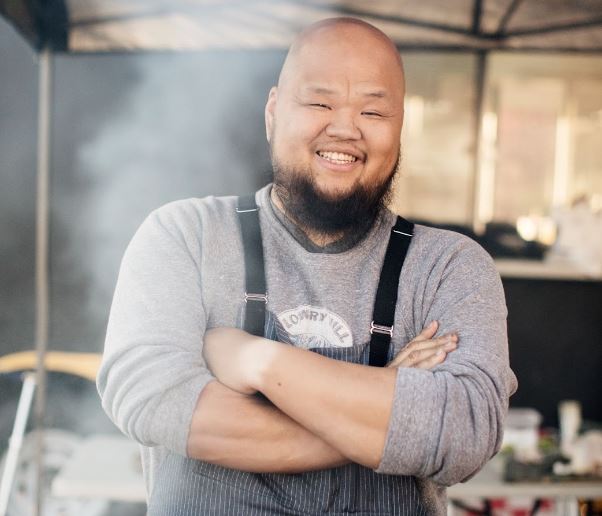 Chef Yia Vang in the kitchen with his arms folded