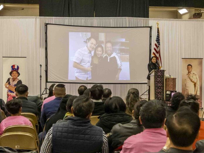 Mourner watch a slide show memorializing Tou Ger Xiong