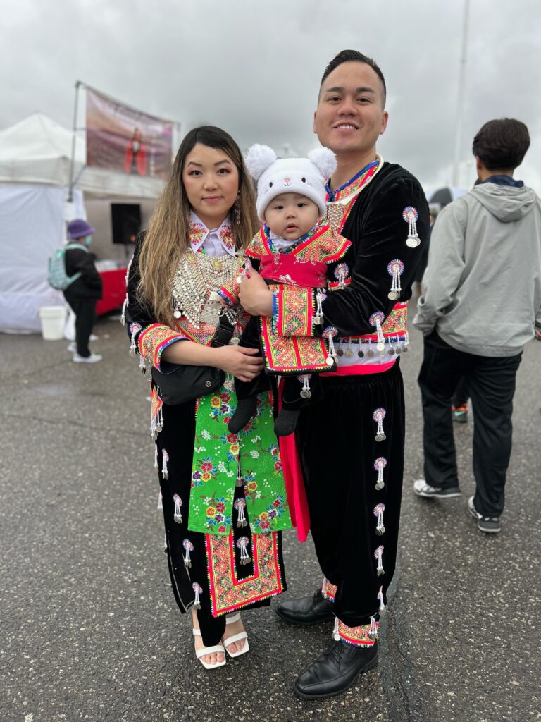 A young family in ethnic Hmong clothing at the Fresno Hmong Cultural New Year Celebration. Photo by Jia H. Jung