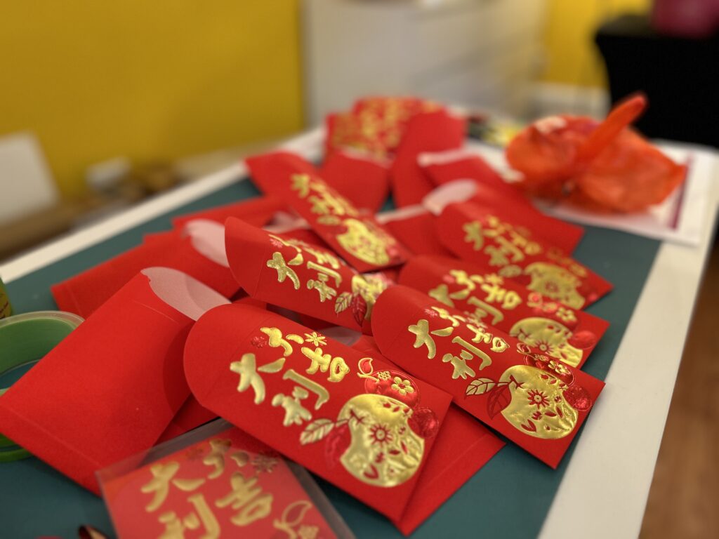 Red and gold funereal envelopes, stuffed with the blessings of a hard candy and a one dollar bill. at Ayudando Latinos a Soñar (ALAS) Casita and Garden in Half Moon Bay before the Corazón del Campesino Memorial Evening commemorating the mushroom farm shootings on Jan. 23