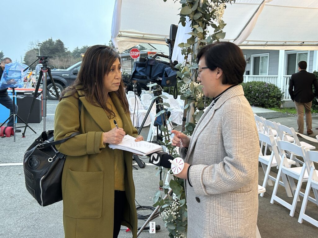 Sao Leng U, social services director at Self-Help For The Elderly, speaking to Amber Lee of Channel 2 at Corazón del Campesino Memorial Evening at the Ayudando Latinos a Soñar (ALAS) Casita and Garden at 636 Purissima Street Half Moon Bay shooting memorial event on Jan. 23, 2024