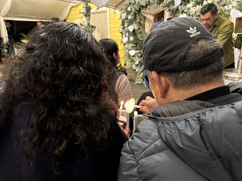 Wang Ying Ze (王英则), left, and Liu Jin Sheng (刘金生), right, lit candles at the vigil remembering their coworkers who were killed last year. Half moon bay mushroom farm shootings, Corazón del Campesino Memorial Evening