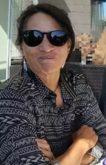 Alice “Alyx” Kamakaokalani Herrmann is wearing sunglasses and poses with her arms folded