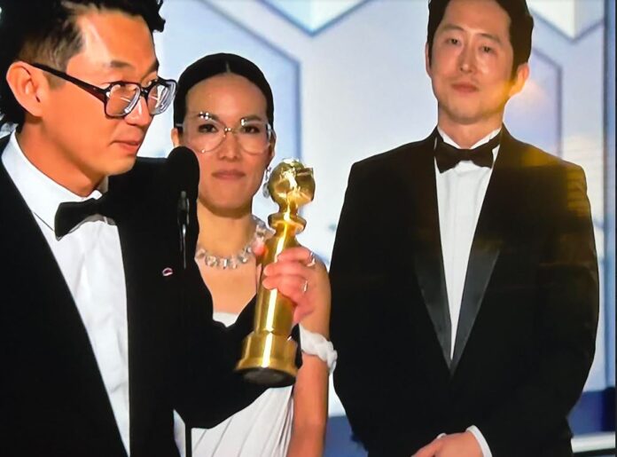 Beef creator Lee Sung Jin accepts the award for Best limited series with Ali Wong and Steven Yeun in the background.