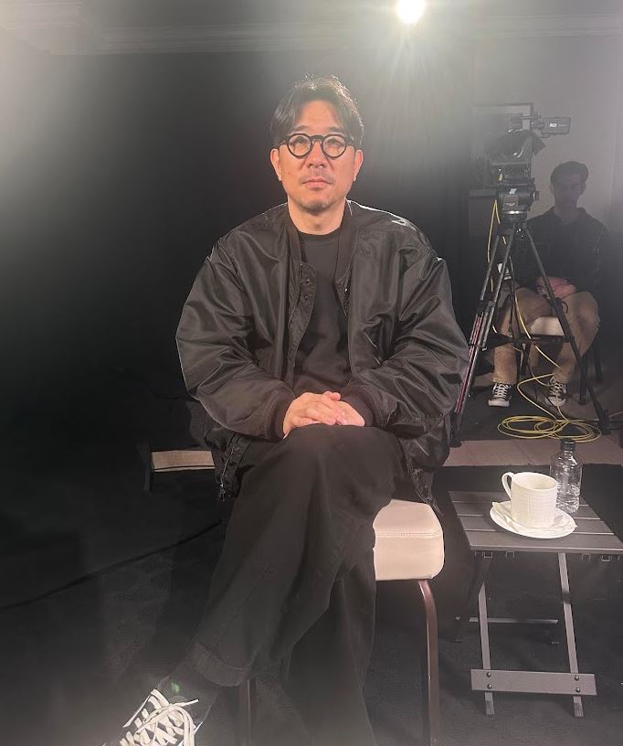 Park in Je poses on his director's chair 