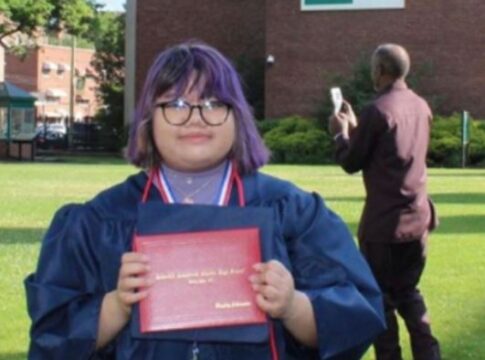 Hayley Alvarado holds up her high school diploma.