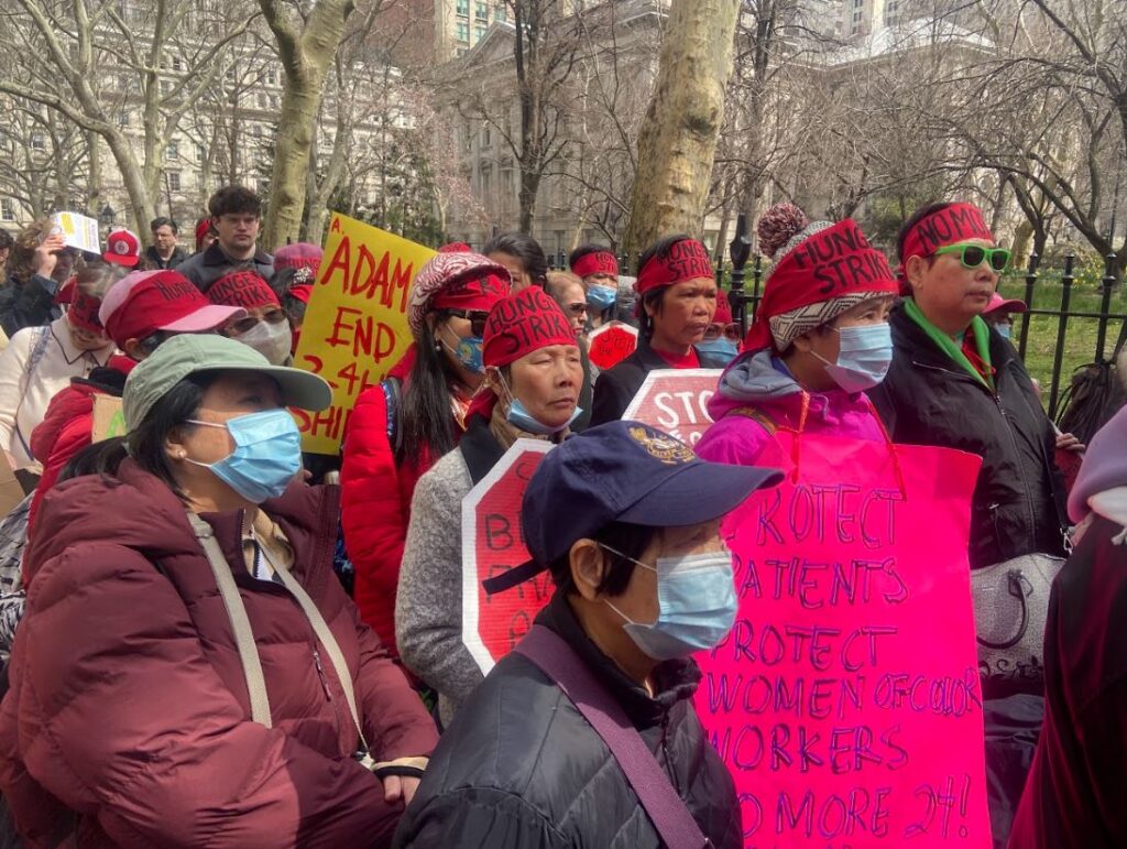 Hunger strikers, wearing red headbands, listen to speakers during the rally kicking off their strike.