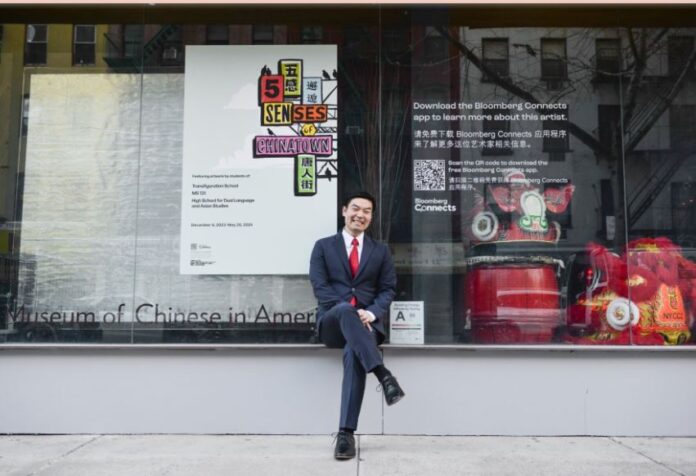 Michael Lee sits with his legs folded outside the Museum of Chinese in America in New York