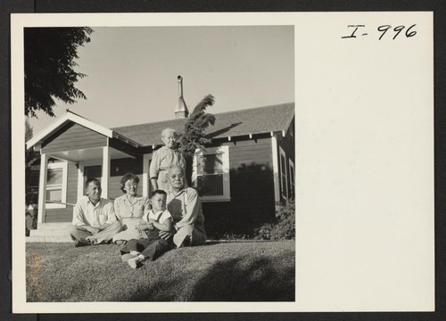 Family sitting in front of home in 1945 in Livingston, CA