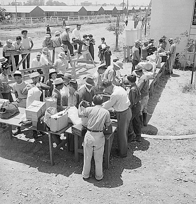 Inspectors look through luggage of Japanese going into prison camp in 1942.
