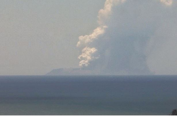 A plume of smoke can be seen from a distance coming from White Island Volcano in 2019