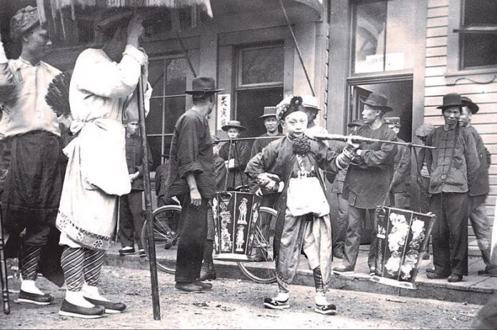 Chinatown in Astoria, Oregon with Chinese festival participants, 1890s.